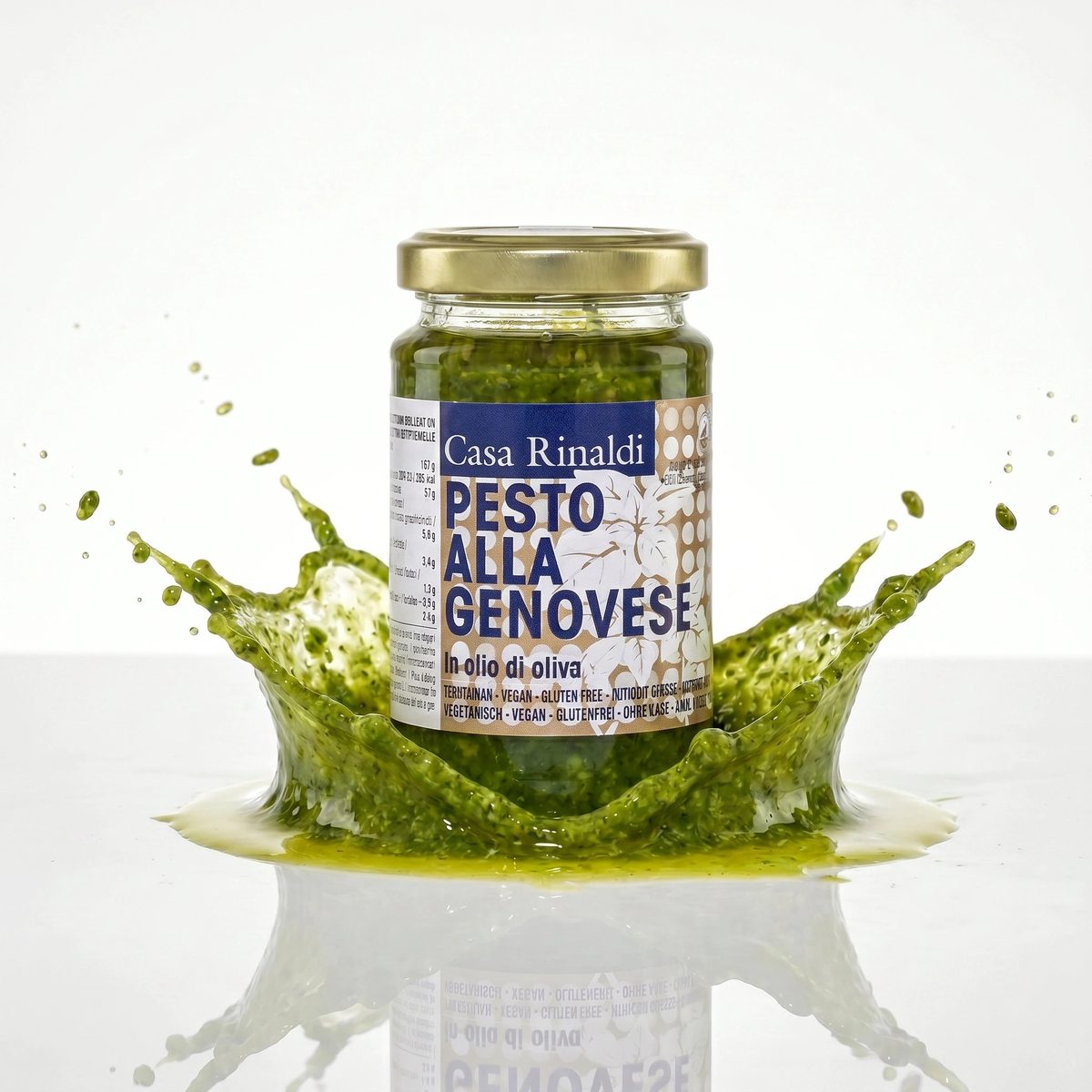 Jar of Casa Rinaldi Pesto Alla Genovese with a splash of pesto around it on a white background
